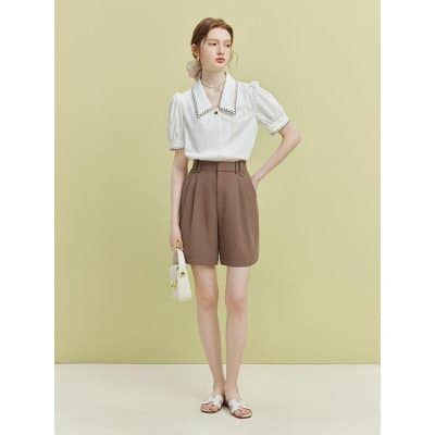 Beautiful casual outfit for women with stylish white blouse and high-waisted brown shorts perfect for summer wear.