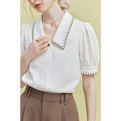 Elegant white blouse with detailed collar and puffed sleeves for stylish eye care professionals. Perfect for optometry clinics or optical stores, combining comfort and fashion.