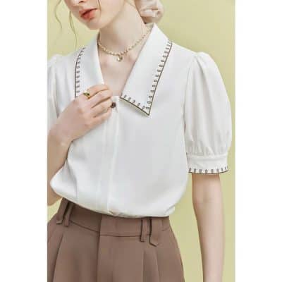 Elegant white blouse with detailed collar and puffed sleeves for stylish eye care professionals. Perfect for optometry clinics or optical stores, combining comfort and fashion.