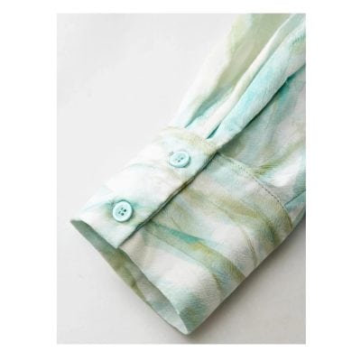 Soft pastel blouse with floral design and functional buttons, ideal for healthcare wear or medical office staff, combining fashion with professional comfort.