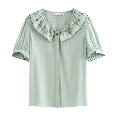 Elegant women's blouse with embroidered butterfly and floral details, soft pastel color, button-up front, and scalloped sleeve edges, perfect for stylish casual or semi-formal wear.