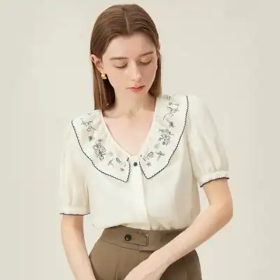 Stylish women’s blouse with intricate embroidery and scalloped edges, perfect for casual or dressy occasions. Made with high-quality fabric for comfort and style.