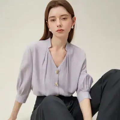 Stylish women's blouse with a V neckline, button details, and soft fabric perfect for office or casual wear. Features comfortable three-quarter sleeves.