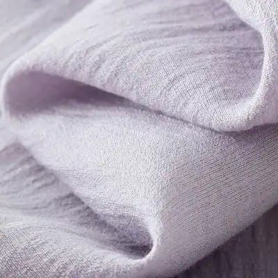 Close-up of silky, smooth, lavender-colored fabric highlighting soft texture and subtle sheen for luxury clothing or accessories.