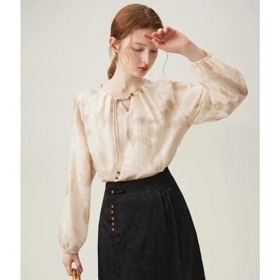 Stylish beige women's blouse featuring pearl buttons, long sleeves, and a relaxed fit, ideal for office, casual outings, or everyday fashion. Perfect for enhancing your wardrobe with sophisticated apparel.