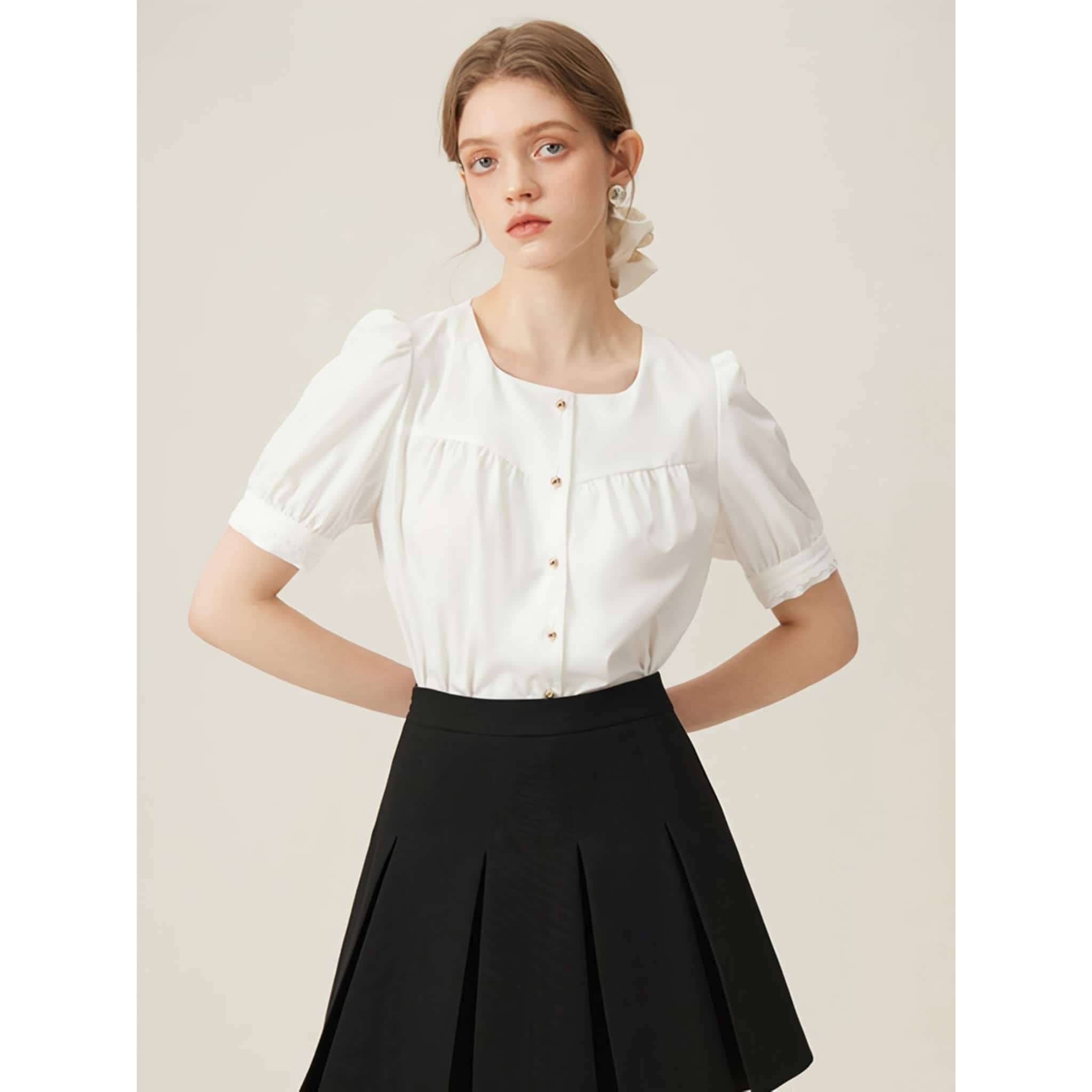 A stylish white blouse designed for women, featuring puff sleeves, a classic round neckline, and gold buttons, ideal for professional or casual wear.