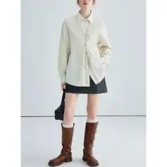 Elegant cream-colored shirt with a lace-up front detail, oversized fit, long sleeves, and a collared neckline, perfect for casual or chic outings.