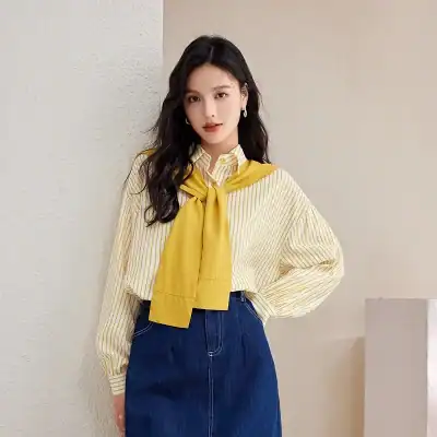 Elegant women's fashion outfit with a yellow scarf, striped blouse, and denim skirt, perfect for casual or formal occasions.