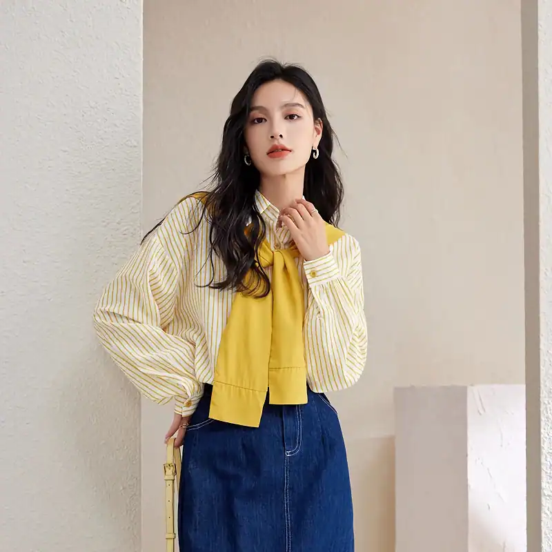 Modern fashion model wearing yellow accent scarf with stylish striped shirt and denim skirt, showcasing trendy eyewear from Monalisa Store for a fashionable look.