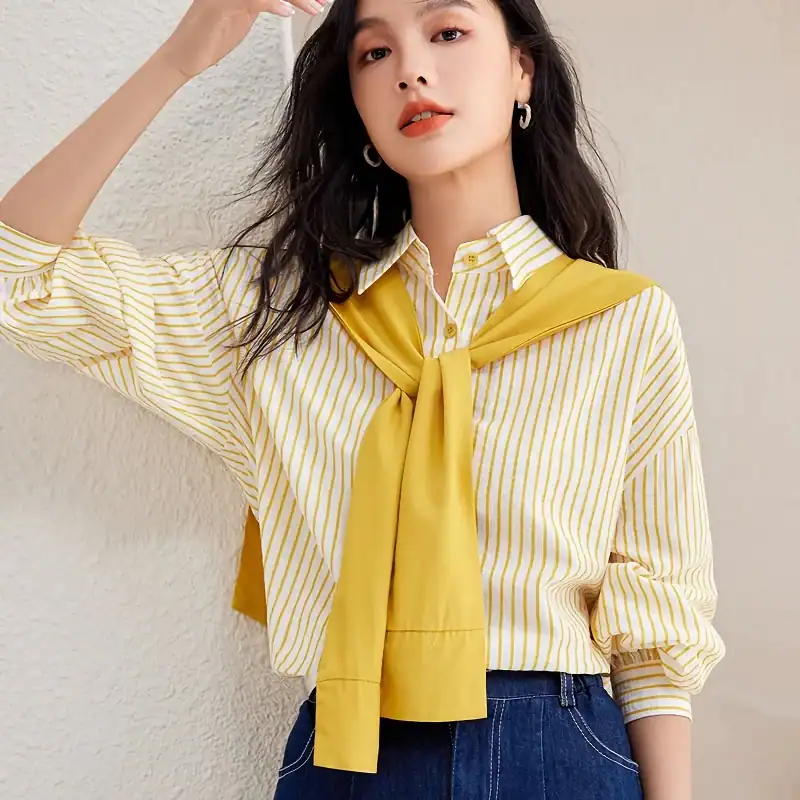 Stylish yellow and white striped blouse with a yellow necktie, perfect for fashionable women seeking trendy optical store apparel.