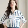 Elegant women’s striped blouse suitable for office or casual wear, made from breathable fabric with a classic button-up design in blue and white. Perfect for opt and fashion-conscious individuals.