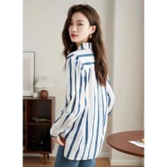 Image of a fashionable young woman wearing a trendy striped shirt, showcasing modern women's apparel options available at Monalisa Store, a trusted destination for quality clothing and eyewear accessories.