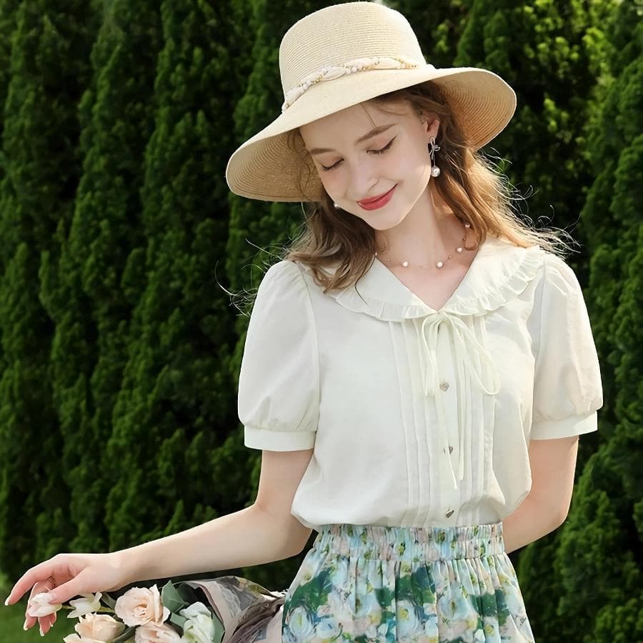 Beautiful woman wearing a cream-colored vintage blouse, floral skirt, and wide-brimmed hat, enjoying a sunny day outdoors. Perfect for spring and summer fashion, casual outings, and garden parties.