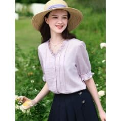 Image showing a woman wearing a stylish wide-brimmed straw sun hat perfect for outdoor activities and sun protection. The hat complements her casual chic outfit amidst a lush garden setting.