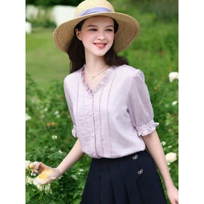 Image showing a woman wearing a stylish wide-brimmed straw sun hat perfect for outdoor activities and sun protection. The hat complements her casual chic outfit amidst a lush garden setting.