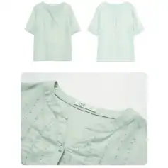 Close-up of a white, embroidered cotton blouse with subtle patterns and a round neckline, perfect for fashionable women's wear.