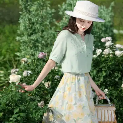 Botanical-inspired summer outfit for women with light green blouse and floral skirt, perfect for outdoor events and garden gatherings.