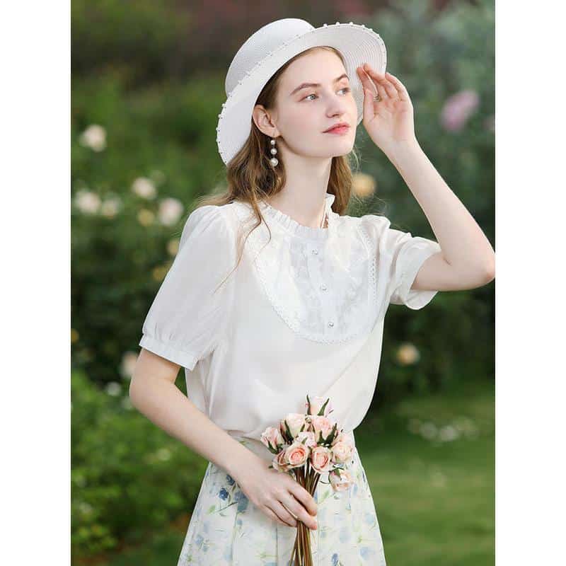 Beautiful young woman in white dress and hat holding pink roses, outdoor fashion, floral accessories, summer style, garden setting.