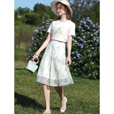 Bright and stylish women's outfit featuring a white casual top and a flowy floral skirt perfect for outdoor outings and spring or summer seasons.