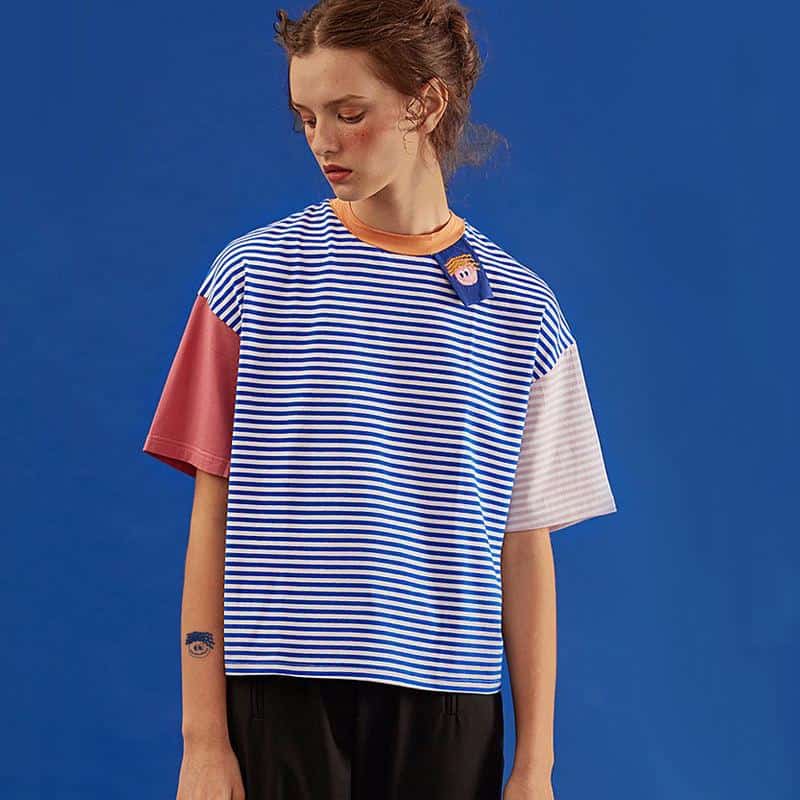 Stylish women's striped t-shirt featuring playful patch detail, ideal for casual wear and fashion-forward looks. Available now at Monalisa Medical Store.