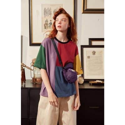 Colorful, casual women's T-shirt with bold color blocks in green, purple, red, yellow, and blue, perfect for trendy everyday wear and stylish optometric accessories.