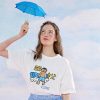 A young woman holding a small blue umbrella against a sky background, showcasing a casual fashion style with a graphic tee. Ideal for eyewear promotion, sunglasses, and optical accessories.