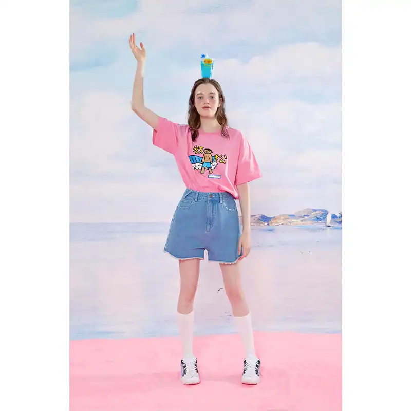 A young woman posing on the beach with colorful accessories, wearing trendy casual clothing and standing on a pink surfboard, perfect for summer fashion and beachwear enthusiasts.