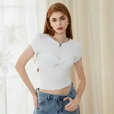 Bright and stylish young woman with fashionable white top and denim jeans, standing indoors with natural lighting. Perfect image for opt store, fashion, and eyewear advertisement.