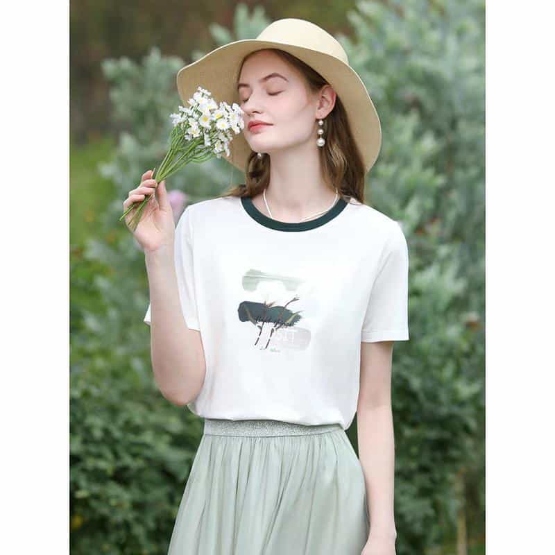 A young woman enjoying nature in a stylish casual outfit, wearing a wide-brim hat and holding a bouquet of daisies, perfect for summer outdoor looks in opt and casual wear.