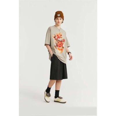 Young woman wearing trendy oversized graphic t-shirt, black culottes, sneakers, and a beanie hat, perfect for casual or streetwear style.
