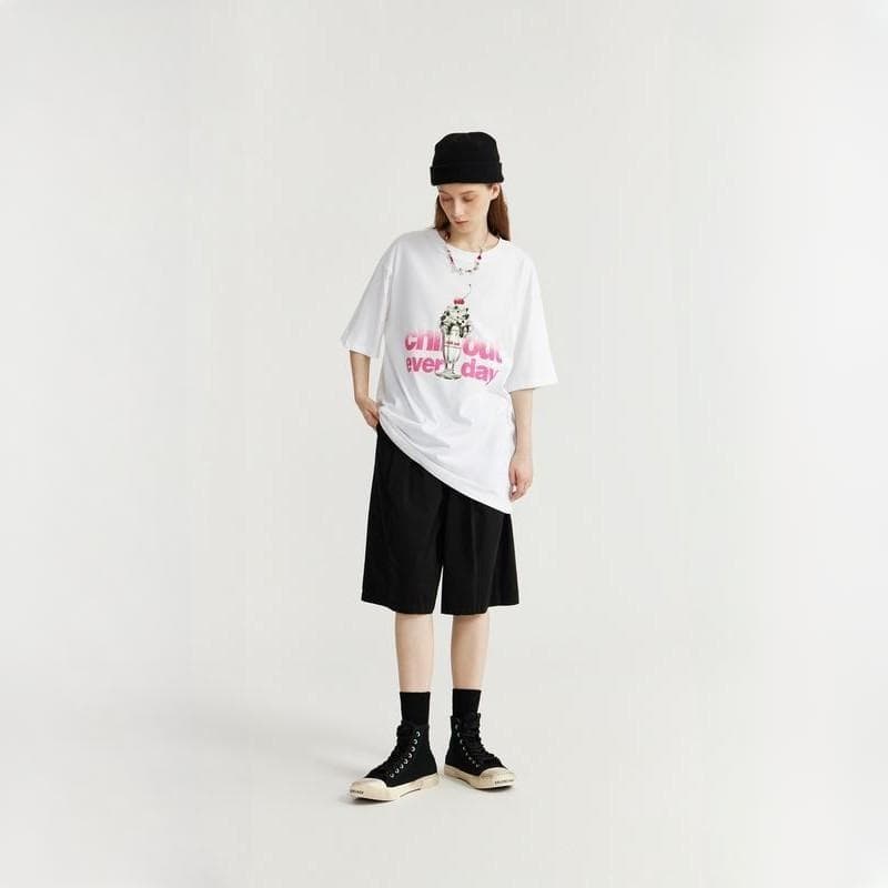 Stylish casual outfit featuring a white graphic T-shirt, black knee-length shorts, and black high-top sneakers, perfect for everyday fashion and comfortable wear.