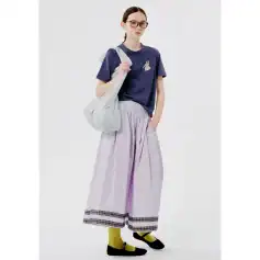 Stylish woman in casual outfit with glasses, tote bag, and wide pants for modern fashion and comfort.