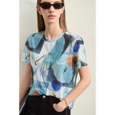 Elegant woman wearing stylish black sunglasses with contemporary abstract top, perfect for fashion-forward eyewear enthusiasts.