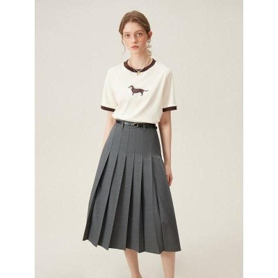 A stylish woman wearing a white Dachshund print t-shirt paired with a grey pleated midi skirt, featuring a casual yet chic look perfect for casual outings or office wear.