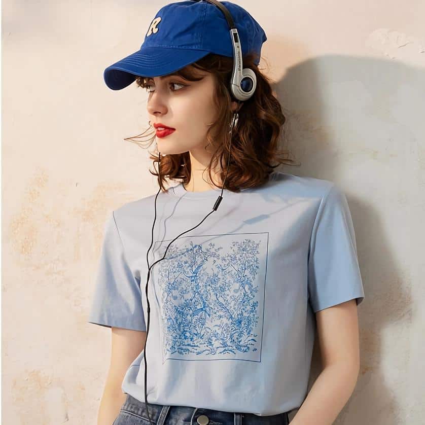 Young woman wearing a blue baseball cap and headphones, casual fashion, outdoor or studio shoot, trendy accessories, aesthetic look, natural makeup, modern style, fashion photography, lifestyle shot.