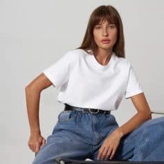 Optical fashion woman wearing casual white T-shirt and high-waisted jeans, showcasing modern style at Monalisa Store for eyewear and optical accessories.