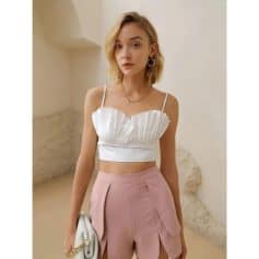 Elegant woman wearing fashionable top and high-waisted pink trousers, showcasing trendy women's clothing and accessories from Monalisa Medical Store.