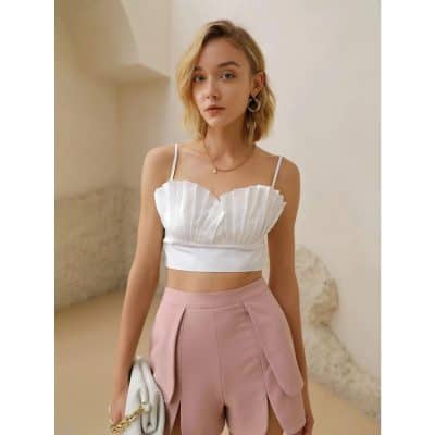 Elegant woman wearing fashionable top and high-waisted pink trousers, showcasing trendy women's clothing and accessories from Monalisa Medical Store.