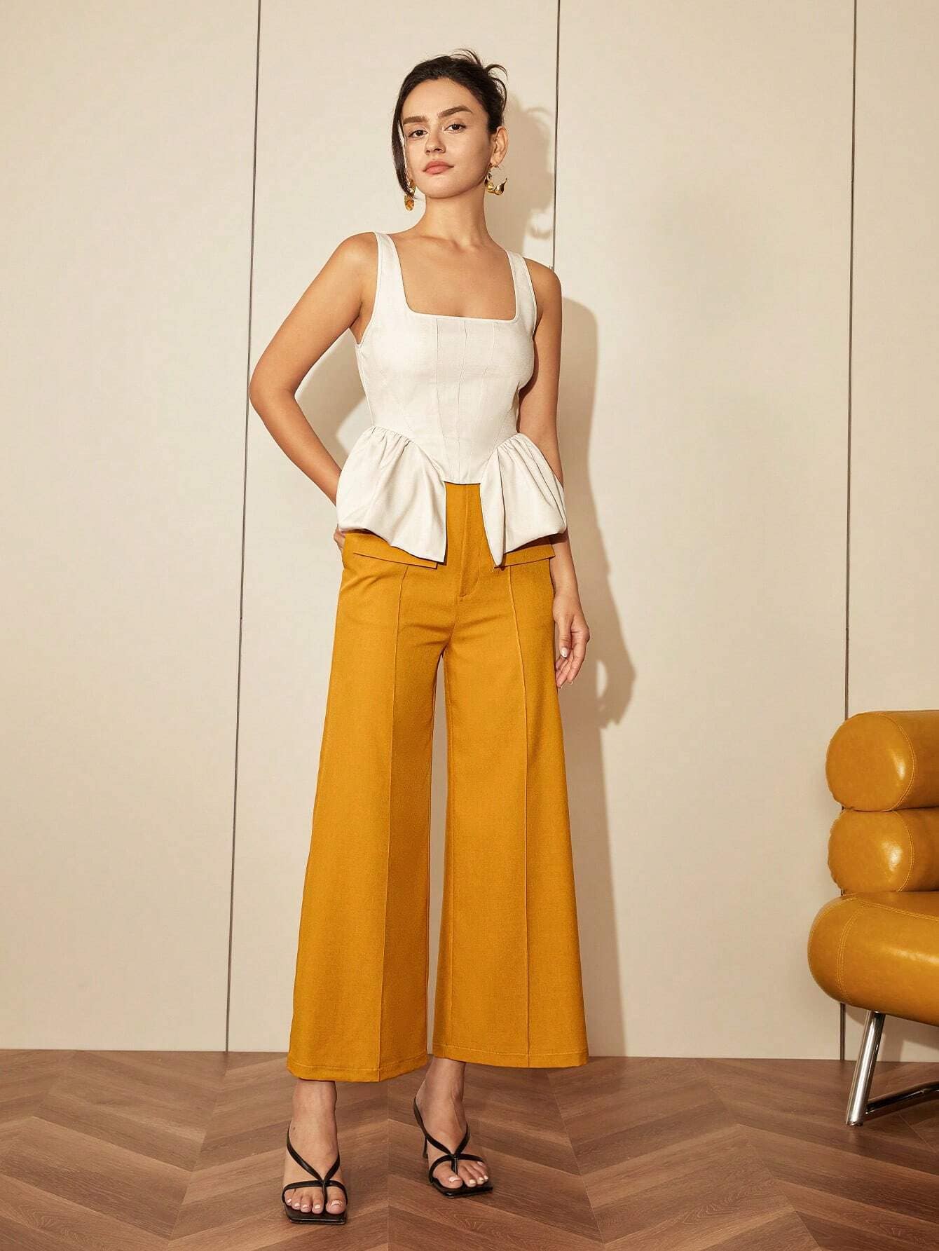 Stylish sleeveless beige top paired with mustard wide-leg trousers, perfect for professional or casual wear.