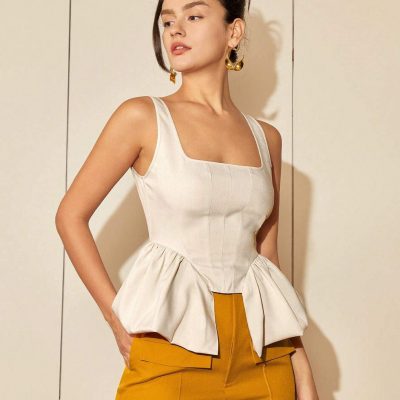 Stylish woman wearing fashionable glasses, chic top, and yellow pants at Monalisa Store, showcasing premium eyewear and fashionable accessories for a sophisticated look.