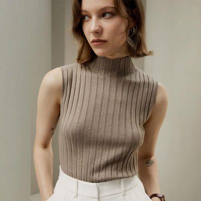 Stylish woman's sleeveless ribbed turtleneck sweater in neutral beige, perfect for fashion-forward outfits and comfortable wear.