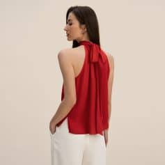 Red women's sleeveless blouse with bow-tie neckline, elegant and stylish for office or casual outings, made from lightweight, breathable fabric. Ideal for fashion-conscious women seeking sophisticated everyday wear.