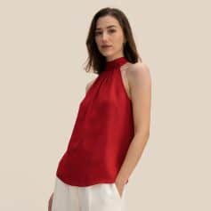 Elegant red sleeveless blouse for women featuring a high neck and sophisticated drape, perfect for stylish office wear or special occasions. Crafted from silky fabric for comfort and elegance.