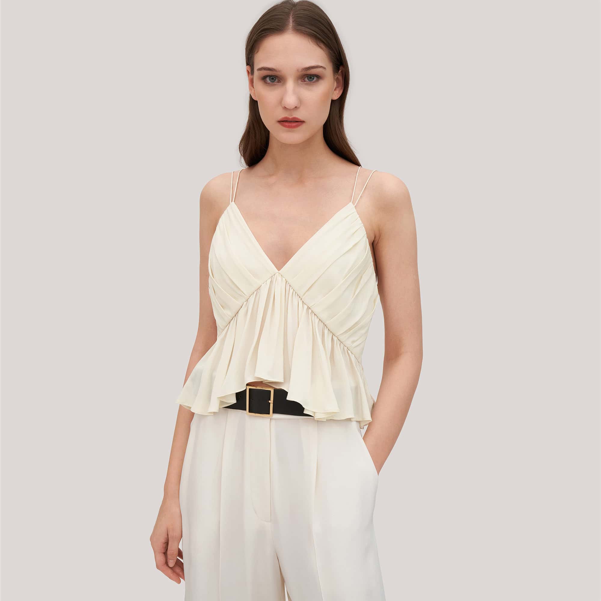 Beautiful cream-colored women's summer top with ruffled bust detail and double spaghetti straps, perfect for stylish casual or dressy occasions.