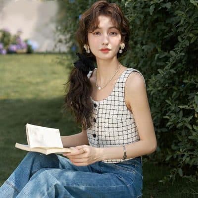 A young woman reading outdoors wearing stylish glasses from MonaLISA Medical Store, showcasing fashionable and high-quality optical products for clear vision and eye health.