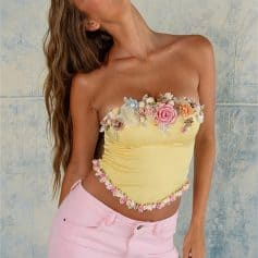 An elegant yellow strapless top embellished with colorful 3D floral appliqués, perfect for fashionable summer wear or special occasions.