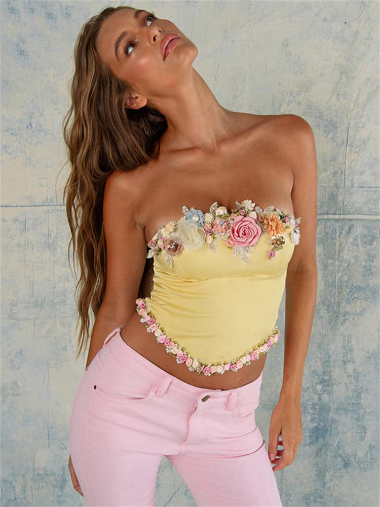 An elegant yellow strapless top embellished with colorful 3D floral appliqués, perfect for fashionable summer wear or special occasions.