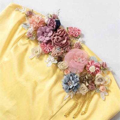 Beautiful floral embellishments and pearls on soft yellow fabric for bridal and special occasion wear. Perfect for wedding gowns, accessories, and elegant styling.
