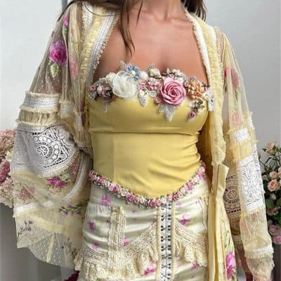 Vibrant floral embroidered blouse featuring lace accents, pastel colors, and intricate beadwork, perfect for fashionable women seeking stylish and unique clothing options.