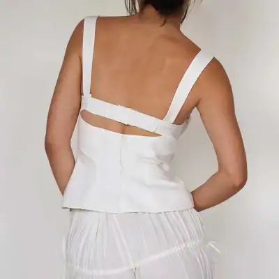 Stylish white sleeveless top with unique strap and back design, perfect for casual wear or summer outings. Crafted from high-quality fabric for comfort and elegance.